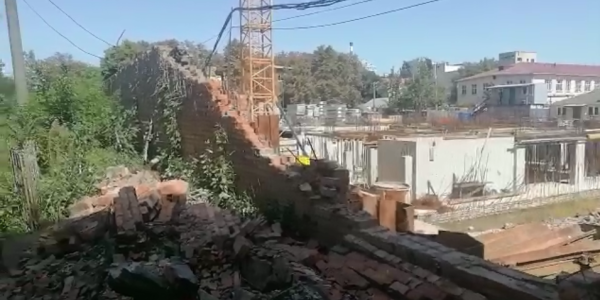 В Краснодаре строители экскаватором обрушили кирпичную стену Всесвятского кладбища