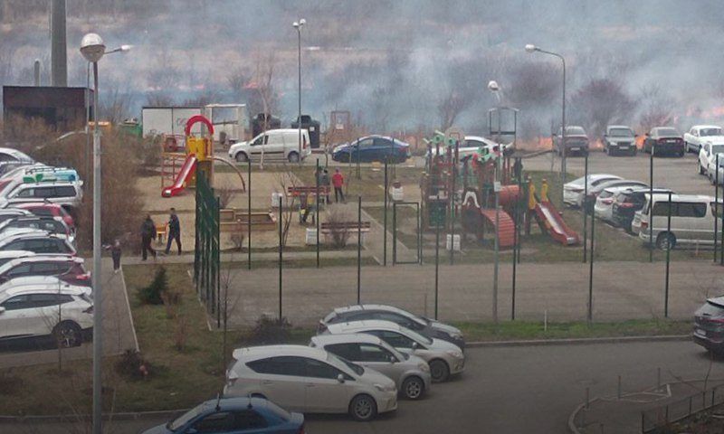 Сухая трава загорелась возле припаркованных машин в Краснодаре