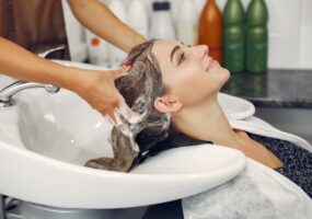 Hairdresser washing head her client. Woman in a hair salon
