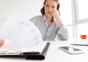 Cropped photo of serious brunette girl reading papers while siti