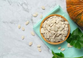 pumpkin seed put in wooden bowl on white marble floor